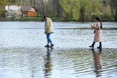 Перехожі йдуть по підтопленій стежці в Гідропарку у Києві, 17 квітня 2023 року Перехожі йдуть по підтопленій стежці в Гідропарку у Києві, 17 квітня 2023 року