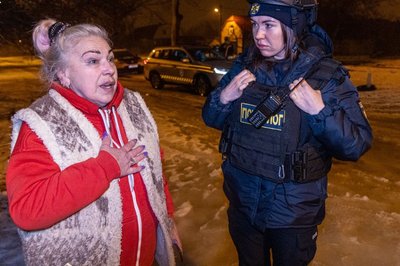 Жінка та працівниця ДСНС на місці російської атаки в Харкові, 26 лютого 2026 року Жінка та працівниця ДСНС на місці російської атаки в Харкові, 26 лютого 2026 року