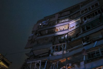 Катерина з батьком виглядають з вікна сьомого поверху в очікування поки до них доберуться рятувальники, Дніпро, 14 січня 2023 року. Катерина з батьком виглядають з вікна сьомого поверху в очікування поки до них доберуться рятувальники, Дніпро, 14 січня 2023 року.