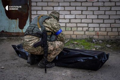 Військовий схилився до тіла свого загиблого друга на території мілького моргу у Миколаєві, березень 2022 року. 18 березня росіяни ракетою вдарили по казармі 79 окремої десантно-штурмової бригади у Миколаєві.