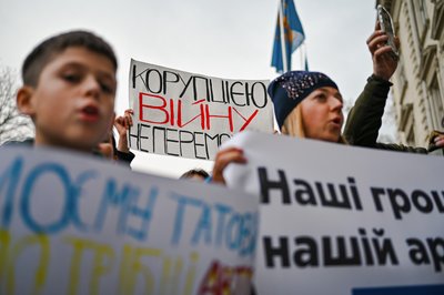 Демонстрант тримає плакат "Війну з корупцією не виграєш" Демонстрант тримає плакат "Війну з корупцією не виграєш"