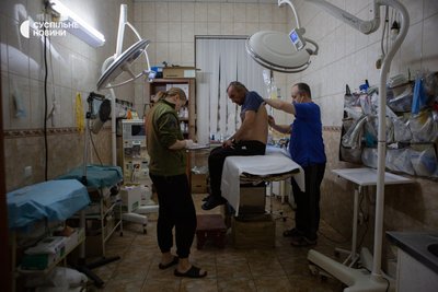 Медики перевіряють стан пораненого бійця у стабпункті Медики перевіряють стан пораненого бійця у стабпункті