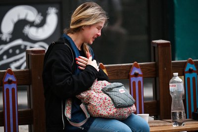 Жінка плаче біля будинку у Києві, на який упали частини збитої російської ракети