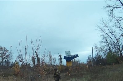 Український військовослужбовець неподалік стели на в'їзді в Куп'янськ Український військовослужбовець неподалік стели на в'їзді в Куп'янськ