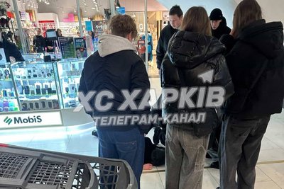 Молоді люди, які стоять біля 22-річного чоловіка, що впав з ескалатора у ТЦ "НІкольський", 14 лютого 2026 року Молоді люди, які стоять біля 22-річного чоловіка, що впав з ескалатора у ТЦ "НІкольський", 14 лютого 2026 року