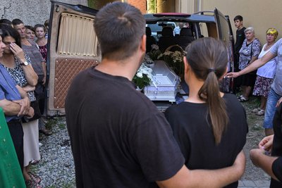 Батьки під час церемонії прощання з 8-річним хлопчиком, який загинув через обстріл у Коломиї
