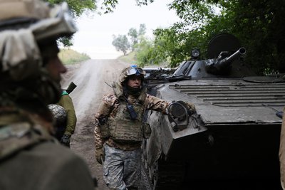 Українські військові стоять біля свого БТР поблизу Бахмута