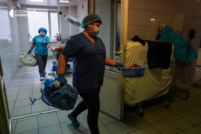 Після кожної операції медсестри та санітарки прибирають операційну — збирають на підлозі брудне ганчірʼя, використані трубки, тампони, марлі, повʼязки, забирають непотрібні апарати. Київ, січень 2023 року.