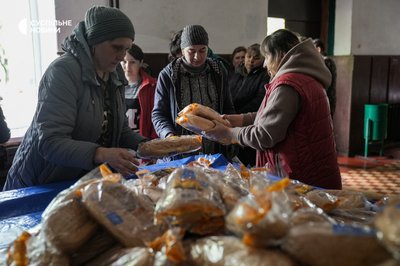Анна (в центрі у чорній хустці), вдова загиблого українського військового Олександра, стоїть разом з іншими односелянами у черзі за хлібом у Підвисокому, квітень 2023 року