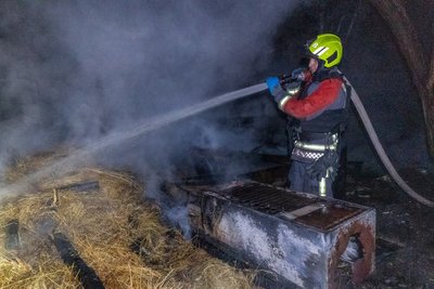 Рятувальник гасить пожежу у господарській споруді Рятувальник гасить пожежу у господарській споруді