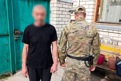 Працівник поліції затримує підозрюваного Працівник поліції затримує підозрюваного