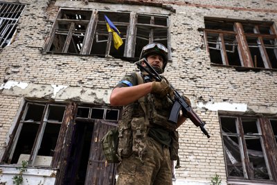 Український військовий біля Будинку культури у звільненому селі Благодатне
