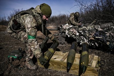 Українські військовослужбовці готують 105 мм снаряд для гаубиці для обстрілу російських позицій біля Бахмута, 14 березня 2023 року