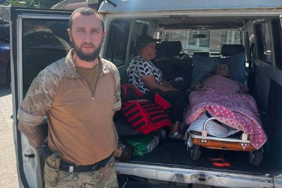 Поліцейський і маломобільна жінка, яку евакуювали з небезпечної території на Харківщині, серпень 2026 року Поліцейський і маломобільна жінка, яку евакуювали з небезпечної території на Харківщині, серпень 2026 року