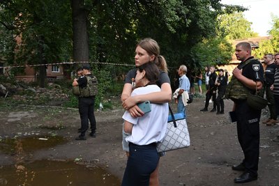 Місцеві жителі біля будинку, в який влучив російський безпілотник у Сумах