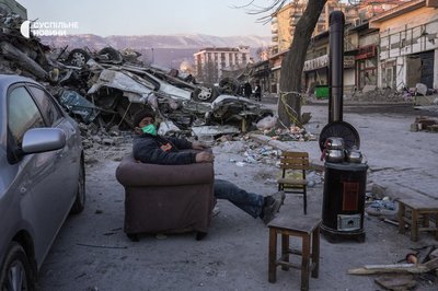 Чоловік гріє чай на буржуйці біля руїн в одному з кварталів зруйнованого землетрусом міста Кахраманмараш, Туреччина, 12 лютого 2023 року.