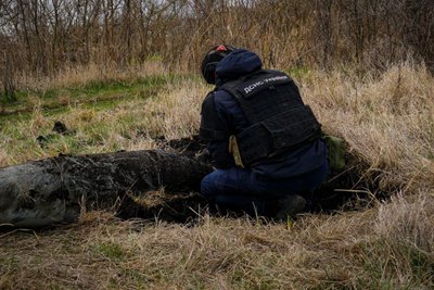 Працівник ДСНС вилучає нерозірвану ФАБ-500, яку знайшли в Слатиному Харківської області