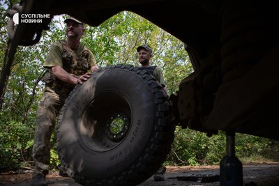 Механіки мобільної ремонтної групи міняють колесо на Humvee Механіки мобільної ремонтної групи міняють колесо на Humvee