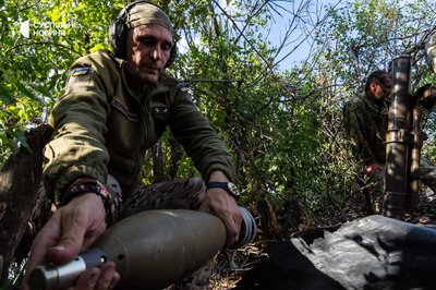 Мінометник "Айдару" Михайло подає міну для чергового пострілу