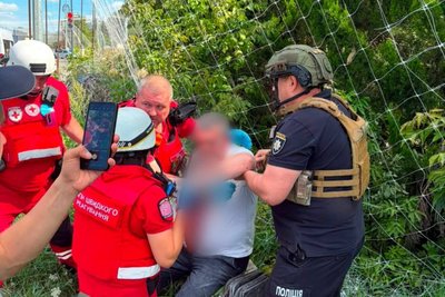 Медики та поліцейські надають допомогу пораненому чоловіку Медики та поліцейські надають допомогу пораненому чоловіку