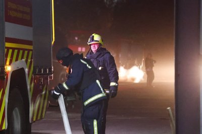 Рятувальники біля пожежної машини Рятувальники біля пожежної машини