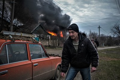 Місцевий житель біля палаючої після обстрілу будівлі у Костянтинівці Донецької області, 15 березня 2023 року