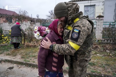 Командир третьої роти батальйону "Цунамі" з позивним "Біджо" втішає бабусю, яка подарувала йому букет з власного квітника у звільненому селі на Херсонщині, листопад 2022 року.
