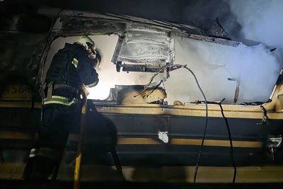 Працівник ДСНС біля обгорілого вагона поїзда, по якому завдали влучань росіяни, Харківська область, 27 січня 2026 року