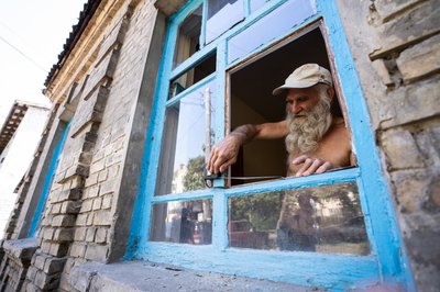 Чоловік заміряє шибку, яку вибила ударна хвиля під час ракетного обстрілу Черкас 21 вересня