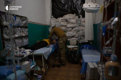 Санітар оглядає пораненого бійця у стабілізаційному пункті Санітар оглядає пораненого бійця у стабілізаційному пункті