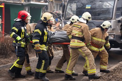 рятувальники несуть тіло загиблого, ДСНС розбирає завали після обстрілу