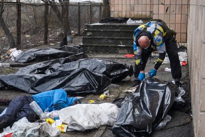 Волонтер збирає тіла закатованих чоловіків у Бучі Волонтер збирає тіла закатованих чоловіків у Бучі