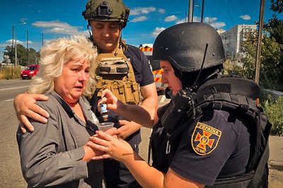 Працівник ДСНС надає допомогу жінці після влучання російського безпілотника Працівник ДСНС надає допомогу жінці після влучання російського безпілотника