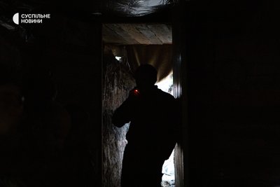 Військовий курить біля входу у спостережний бліндаж Військовий курить біля входу у спостережний бліндаж