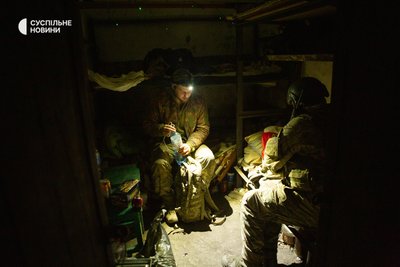 Бійці артилерійського розрахунку сидять в укритті