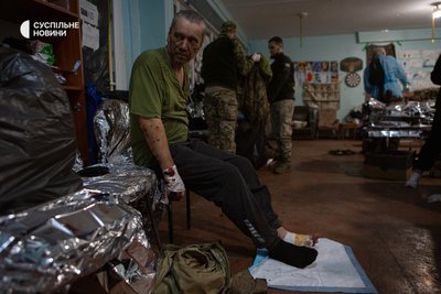 Військовий очікує на допомогу медиків після евакуації з поля бою Військовий очікує на допомогу медиків після евакуації з поля бою