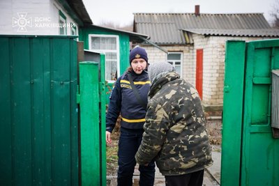 Працівник ДСНС спілкується з мешканкою підтопленого подвір'я Працівник ДСНС спілкується з мешканкою підтопленого подвір'я