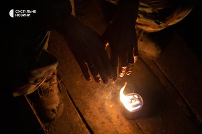 Військовий гріється від окопної свічки на спостережній позиції Військовий гріється від окопної свічки на спостережній позиції