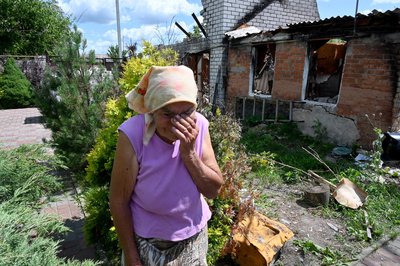 Марія біля свого будинку, зруйнованого обстрілами в селі Борщова на Харківщині
