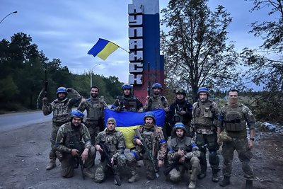 Бійці майбутнього підрозділу "Ахіллес" біля стели на в'їзді в Куп'янськ, 2022 рік Бійці майбутнього підрозділу "Ахіллес" біля стели на в'їзді в Куп'янськ, 2022 рік