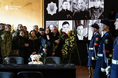 Сім'я інспектора Департаменту комунікації МВС та фотографа Миколи Анацького на церемонії прощання із загиблими в авіакатастрофі у Броварах, Український дім, Київ, 21 січня 2023 року.