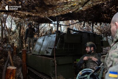 Артилеристи оглядають зовнішню частину САУ