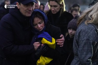 Дружина і донька (на задньому плані) загиблого в авіакатастрофі у Броварах першого заступника міністра внутрішніх справ Євгена Єніна після поховання свого чоловіка на Байковому кладовищі, Київ, 21 січня 2023 року.