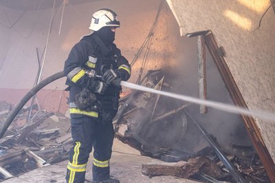 Рятувальник гасить пожежу у торговельному центрі, що не працює, після удару російського безпілотника Рятувальник гасить пожежу у торговельному центрі, що не працює, після удару російського безпілотника