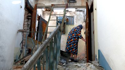 Жінка у зруйнованому будинку на Донеччині Жінка у зруйнованому будинку на Донеччині
