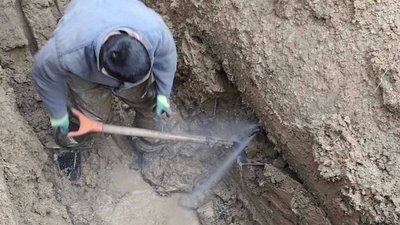 Працівник облводоканалу на місці витоку води