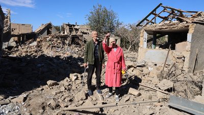 Літня пара на подвірʼї свого зруйнованого обстрілом будинку у Степанівці на Херсонщині