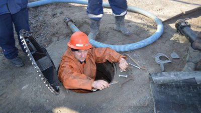 Працівник водоканалу під час ремонтних робіт