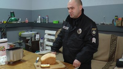 Поліцейський хлібопічка пече хліб в хлібопічці у прифронтовому Кураховому, Донецька область Поліцейський хлібопічка пече хліб в хлібопічці у прифронтовому Кураховому, Донецька область