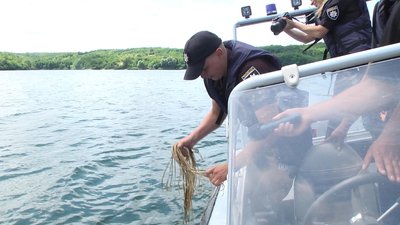 Побачивши у воді саморобний буй, поліцейські витягли рибацьку сітку, ймовірно, поставлену браконьєрами. Фото: Суспільне. Побачивши у воді саморобний буй, поліцейські витягли рибацьку сітку, ймовірно, поставлену браконьєрами. Фото: Суспільне.